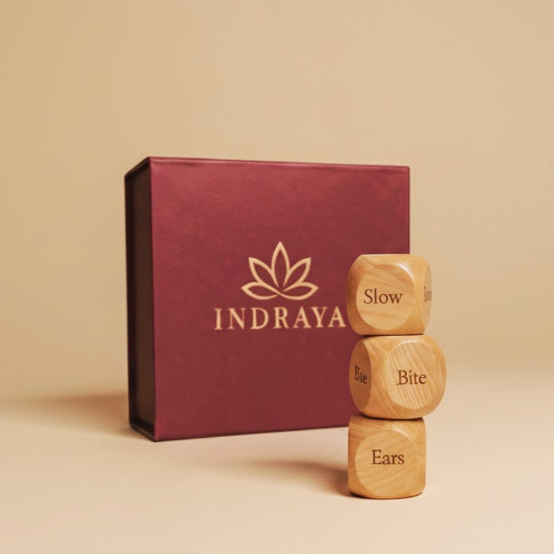 Wooden dice with engraved text in front of an Indraya branded box on a beige background
